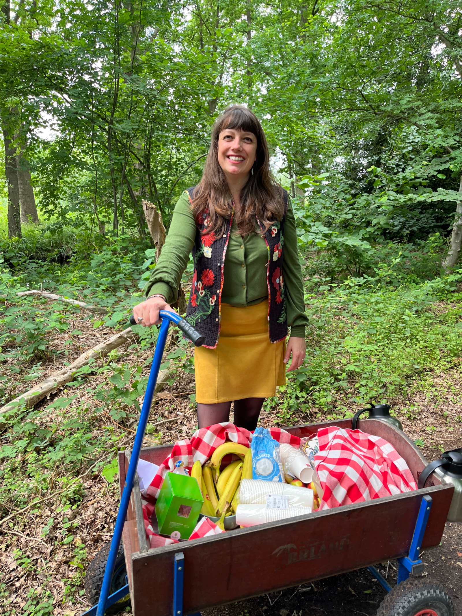 Noor met een bolderkar vol picknickspullen op een bospad