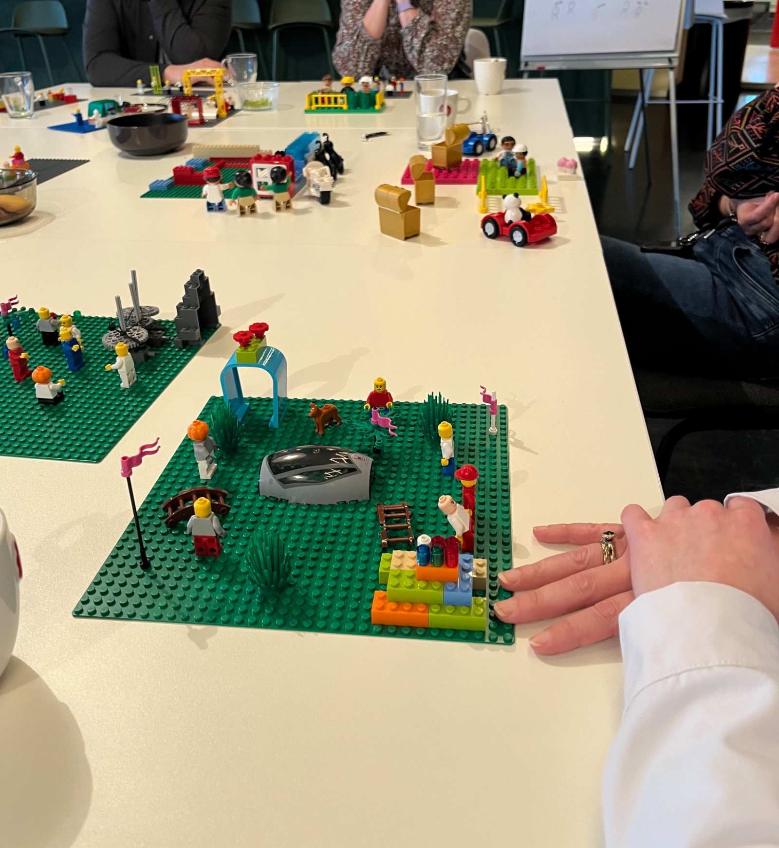 Een team bouwt samen aan tafel met LEGO Serious Play tijdens een workshop